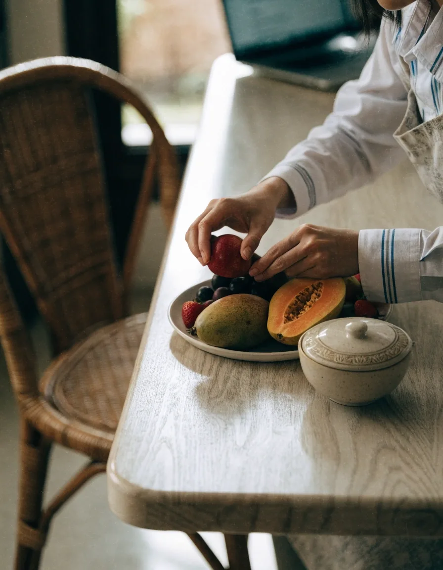 Two hands and a private notebook on a birch table during a nutrition consultation